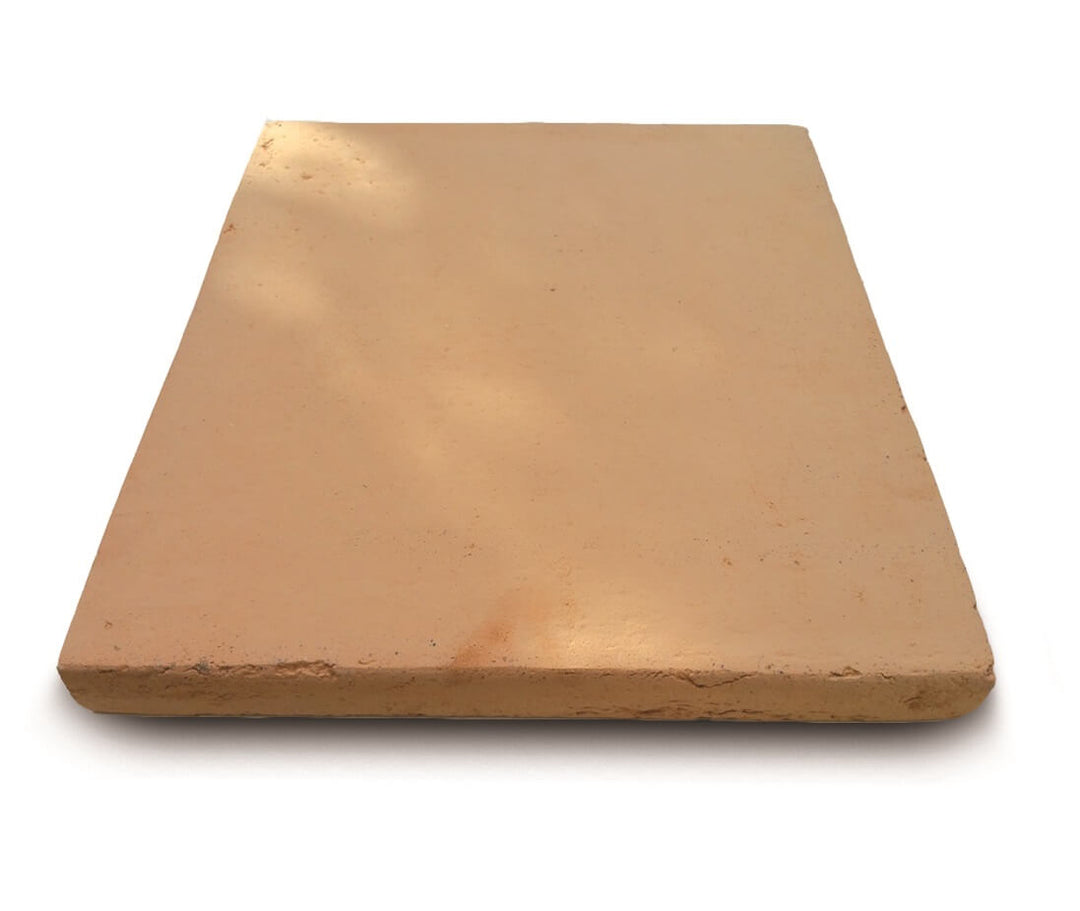 A rectangular, light brown pizza stone with a slightly rough texture. The stone is shown at an angle, highlighting its thickness and smooth surface.