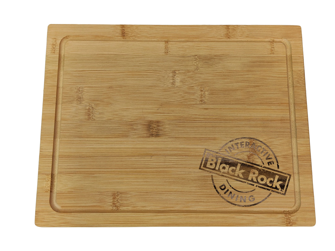 A pack of two rectangular bamboo cutting boards by Black Rock Grill features a shallow groove and stamped logo on the right side, framed by faded text. These sustainable Wooden Serving Steak Boards add convenience to your kitchen.