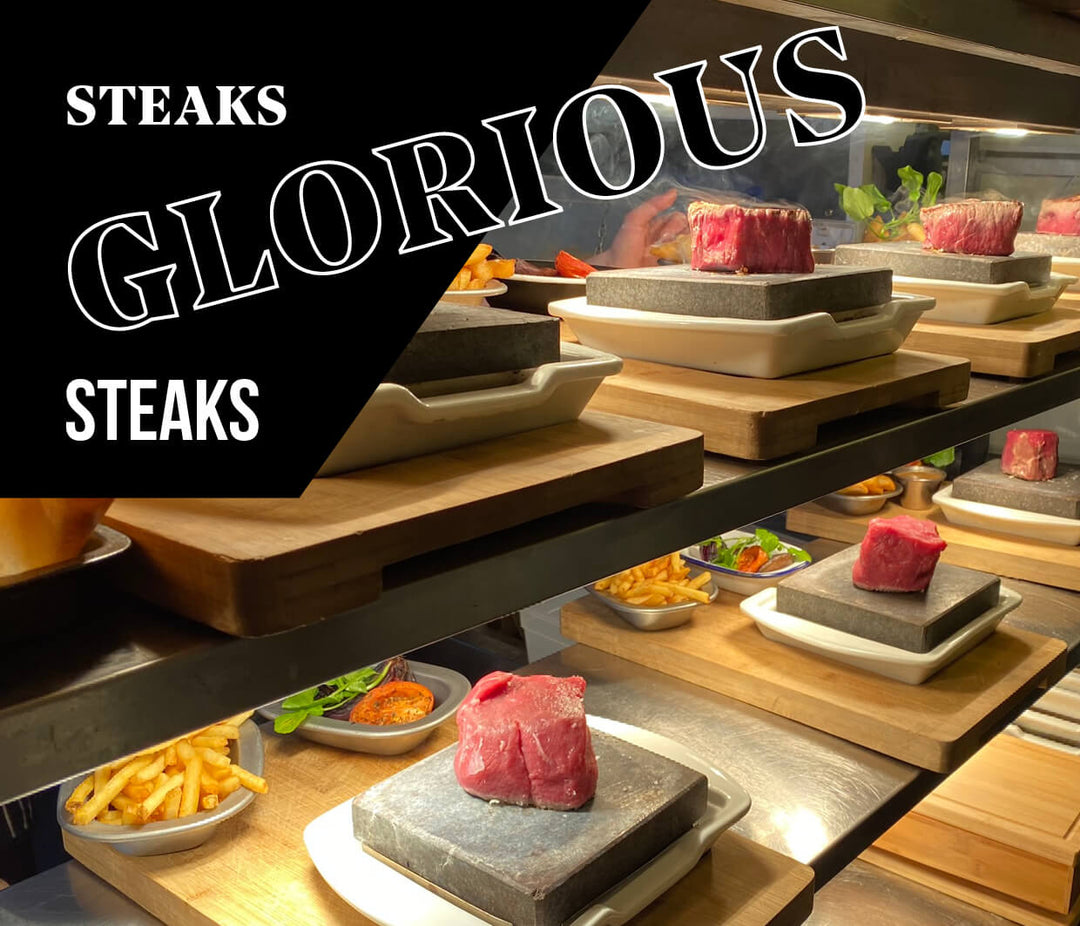 The counter is lined with Black Rock Grills ROXY45 set, ready for a live cooking extravaganza with raw steaks on hot stones. Sides like fries and vegetables complete some dishes, while Steaks Glorious Steaks promises an interactive experience.