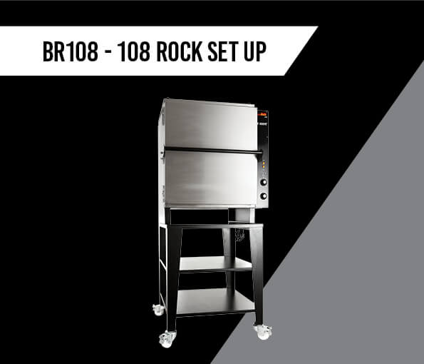 The BR108 by Black Rock Grill features a stylish commercial kitchen oven with two shelves on a wheeled stand, perfect for live cooking demos. Its digital panel ensures interaction against a black-gray diagonal backdrop. BR108 - 108 Rock Set Up is elegantly displayed in the top left corner.