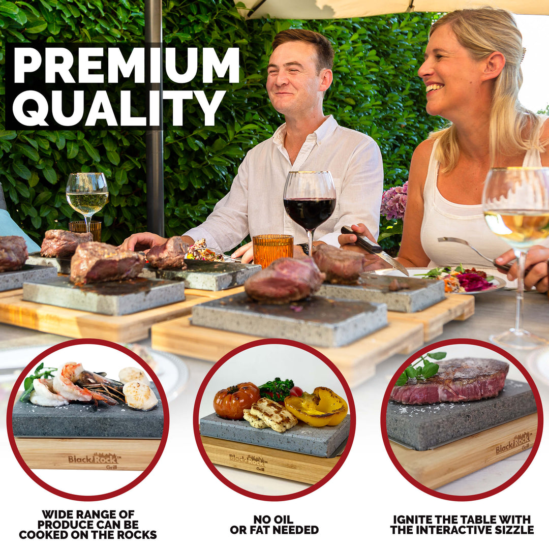 Three people dine outdoors, cooking steak, seafood, and vegetables on the Black Rock Grill Hot Steak Stones Cooking Gift Set. Enjoy a fun, oil-free, interactive dining experience with this versatile Black Rock Grill product.