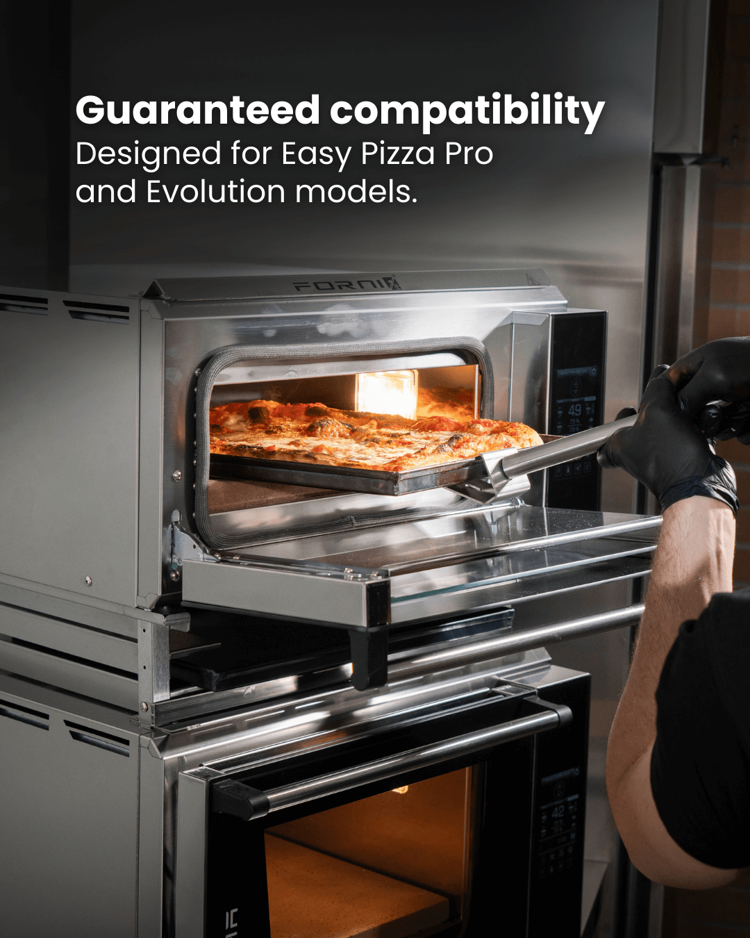 A person wearing black gloves uses a pizza peel to place a pizza into a stainless steel oven. Text above reads: Guaranteed compatibility. Designed for Effeuno PRO & Evolution Ovens. Brand: Black Rock Grill Stacking Kit.