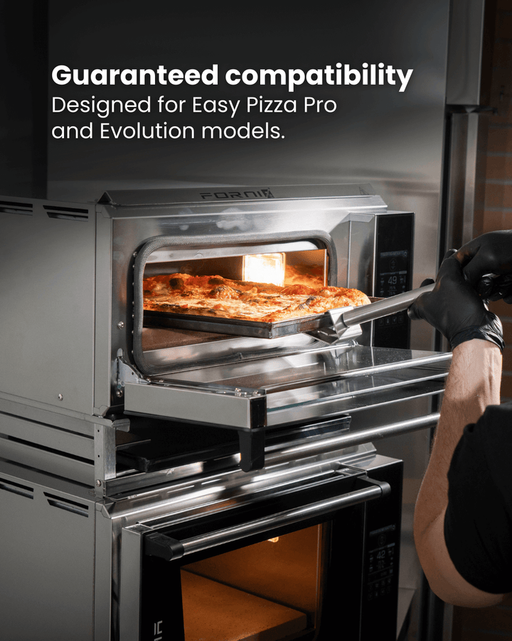 A person wearing black gloves uses a pizza peel to place a pizza into a stainless steel oven. Text above reads: Guaranteed compatibility. Designed for Effeuno PRO & Evolution Ovens. Brand: Black Rock Grill Stacking Kit.