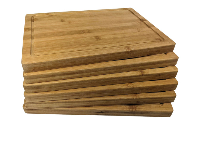A stack of six Wooden Serving Steak Boards by Black Rock Grill, each featuring visible wood grain and a smooth finish, demonstrates sustainable craftsmanship; these bamboo boards, treated with food-grade oil, are neatly aligned against a pristine white background.