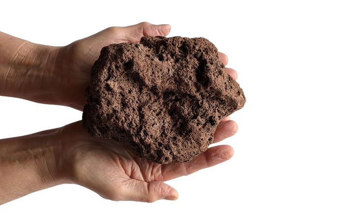 Two hands hold a Black Rock Grill Large Lava Rock (8-15cm), perfect for hydroponics, against a plain white background.