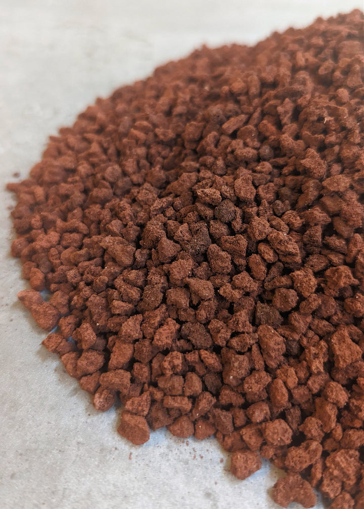 A close-up of Black Rock Grills Horticulture, Aquascaping Lava Rocks (2-10mm, 1KG) on a light surface. The coarse, uneven texture of the reddish-brown granules is ideal for dynamic aquascaping projects.
