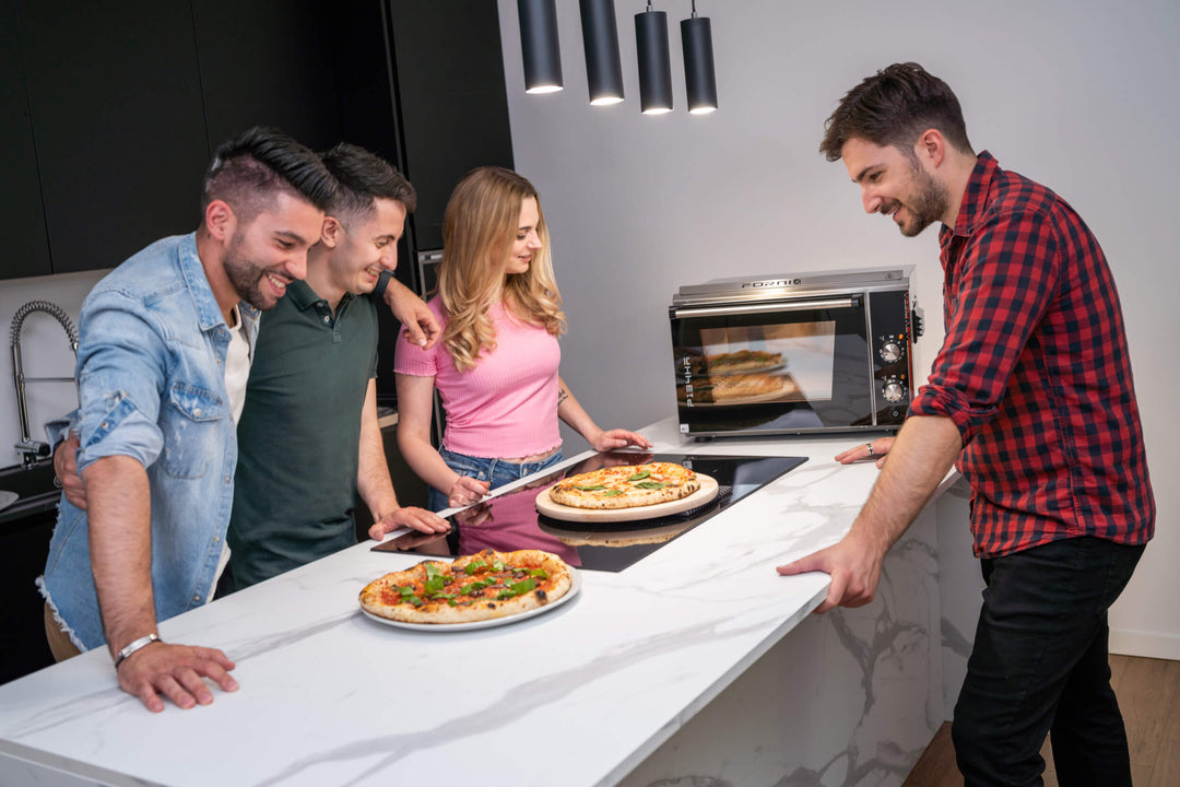 Friends standing round a kitchen countertop looking very proud of the pizzas they just cooked with the Effeuno P134HA Pizza Ovens