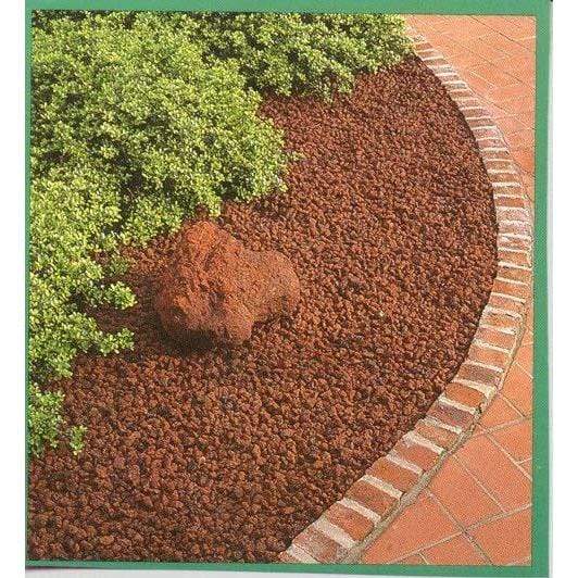 Black Rock Grill Lava Rocks in a garden border with plants