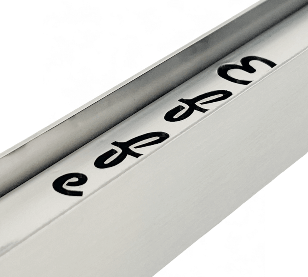 A close-up of a metallic object, likely part of an Effeuno Steamer for baking Bread, reveals partially visible edes engravings. Its sleek design with black lettering on a shiny silver surface promises enhanced moisture control for optimal baking.