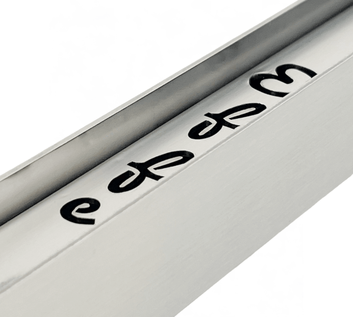 A close-up of a metallic object, likely part of an Effeuno Steamer for baking Bread, reveals partially visible edes engravings. Its sleek design with black lettering on a shiny silver surface promises enhanced moisture control for optimal baking.