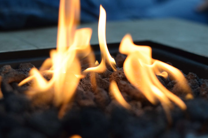 Bright yellow and orange flames dance over Black Rock Grill’s 100% Natural Lava Rocks for Firepit (4-8cm), creating a warm, inviting ambiance with their dark, textured surface. Perfect addition to any gas fire pit.