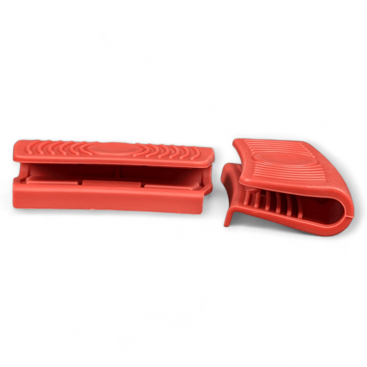 Two Black Rock Grill Silicone Heat Resistant Handle Holder Covers (Pair) in red are shown—one open, one closed—against a white background. Made of food-grade silicone, these grips offer a non-slip hold for hot cookware handles.