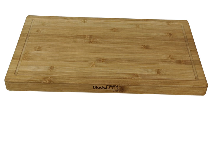 This Large Wooden Serving Board from Black Rock Grill, sized at 44cm x 27cm x 3cm, offers a smooth surface with an edge groove and engraved logo. Made from sustainable bamboo, it displays a natural wood grain ideal for cutting and serving. Available in cases of six.