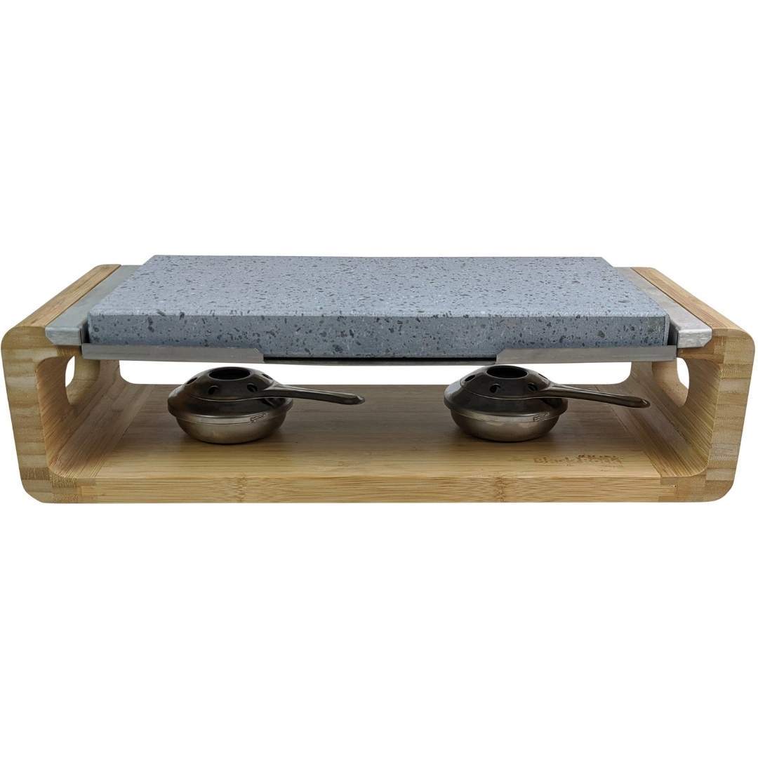 The Steak Stone Sharing Platter & Grill Set by Black Rock Grill features a rectangular granite stone on a wooden frame, ideal for hot stone cooking. Two metal burners with spoons ensure this setup is perfect for tabletop grilling or sizzling steak stones to perfection.