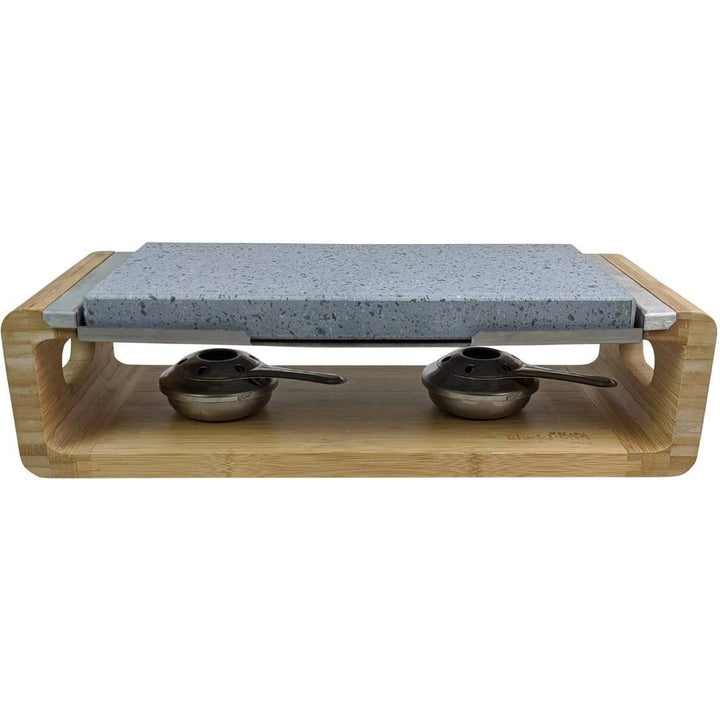 The Steak Stone Sharing Platter & Grill Set by Black Rock Grill features a rectangular granite stone on a wooden frame, ideal for hot stone cooking. Two metal burners with spoons ensure this setup is perfect for tabletop grilling or sizzling steak stones to perfection.