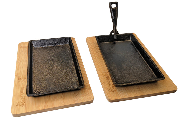 The set features two premium rectangular Cast Iron Fajita Skillet Pans from Black Rock Grill with wood bases. One skillet includes a handle, and both wood bases are engraved with the brand name, adding an elegant touch to your dining experience.