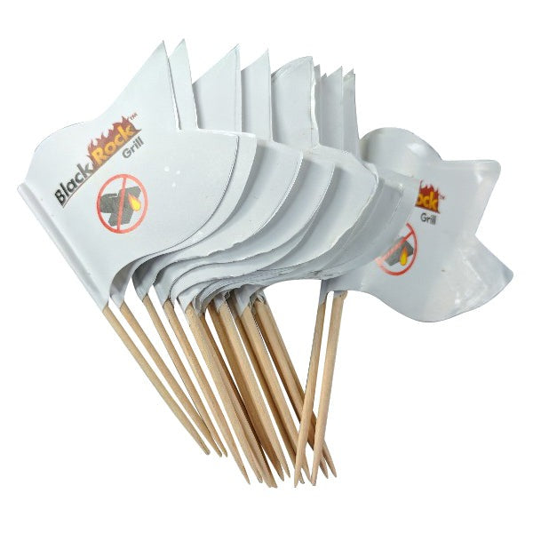 The ROXY12 set from Black Rock Grill includes 12 small white flags with wooden sticks, each featuring a crossed-out frying pan symbol and Black Rock Grill, inviting diners to an interactive dining experience by cooking at the table, turning meals into memorable events.