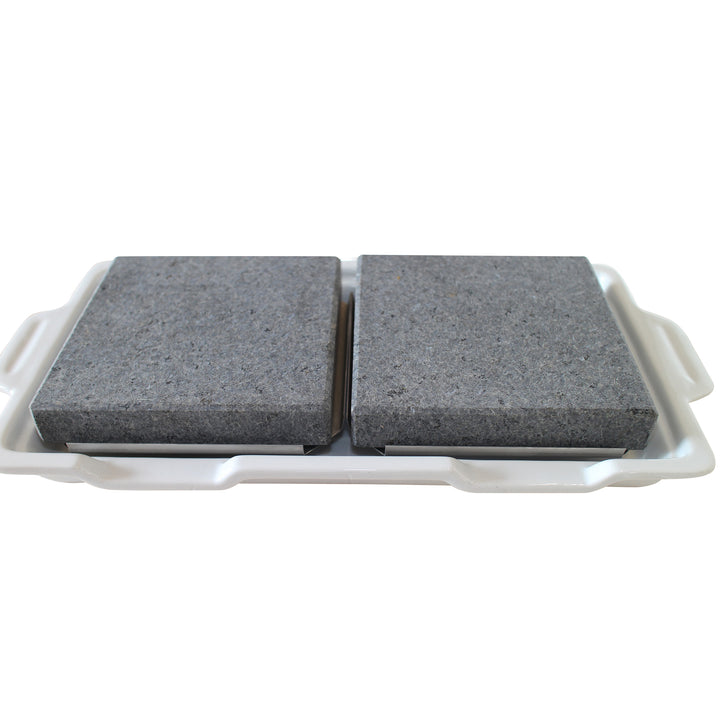 Two gray stone slabs sit on a smooth, handled white porcelain tray, mimicking double rock platters. The slabs have a rough texture and are evenly spaced with a small gap between them, adding elegance to this GP-3 setup by Black Rock Grill.