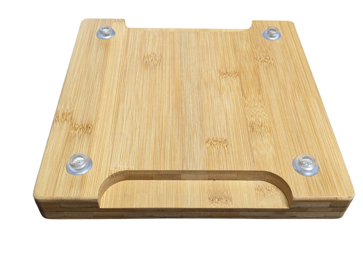 The Black Rock Grill Lava Stone Steak Multi Pack, by Black Rock Grill, includes a rectangular bamboo platter with a cut-out handle and four non-slip pads. The smooth surface showcases the natural wood grain.