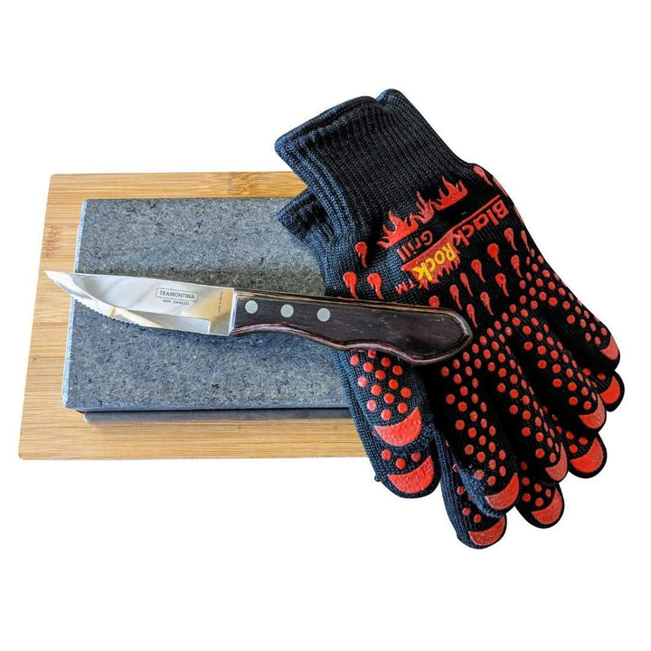 The Black Rock Grill Hot Steak Stones Cooking Gift Set by Black Rock Grill includes a wooden-handled knife, black and red heat-resistant gloves, and a sharpening stone—essential tools for an exceptional steak stone experience.