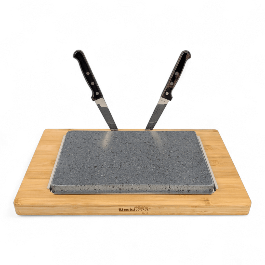 A stone slab set in a wooden tray with two kitchen knives inserted upright into the stone, shown on a white background.