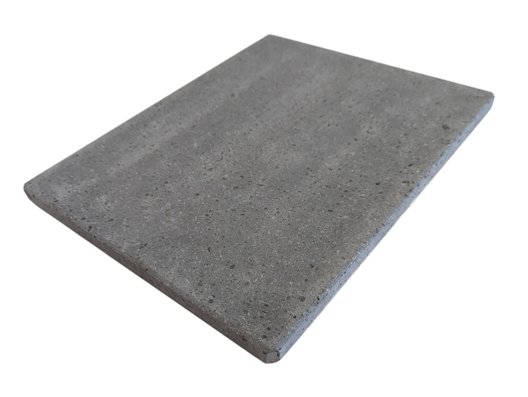 A rectangular, light brown pizza stone with a slightly rough texture. The stone is shown at an angle, highlighting its thickness and smooth surface.