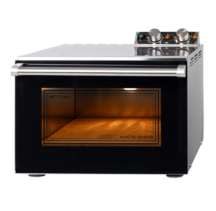 The Macte Nettuno Electric Pizza Oven is a stainless steel countertop oven with a glass door, top control knobs, illuminated interior, and “NETTUNO” and “MACTE OVENS” displayed on the door.