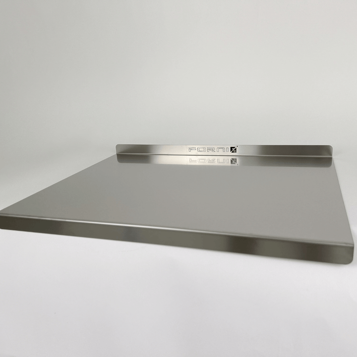 The Effeuno Stainless Steel Pizza Prep Board, a professional food-grade AISI 304 product measuring 50cm, features a sleek rectangular metallic design with raised edges and FORM engraved on the back. It boasts a smooth, reflective surface and rests elegantly against a plain white background.