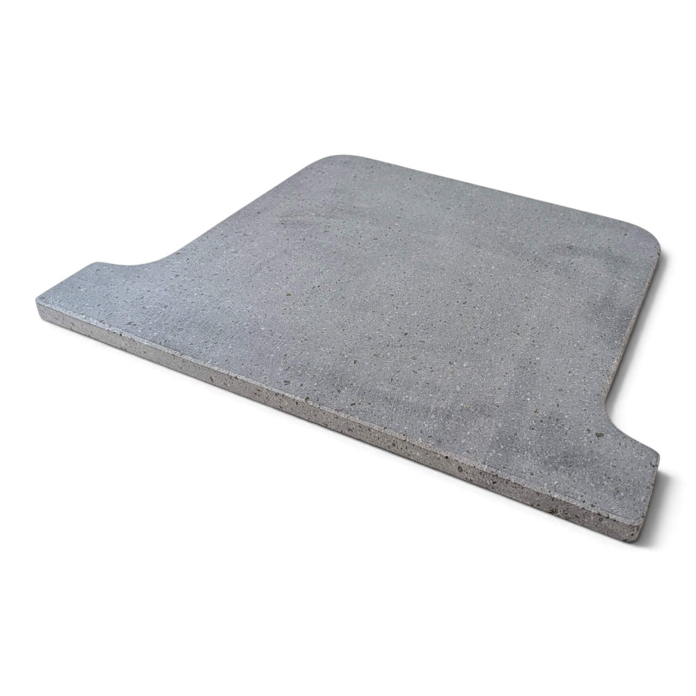Side view of a grey Lava pizza oven stone that fits the ooni koda 16 pizza oven square with rounded corners and a stepped, notched edge on one side, shown on a plain white background.