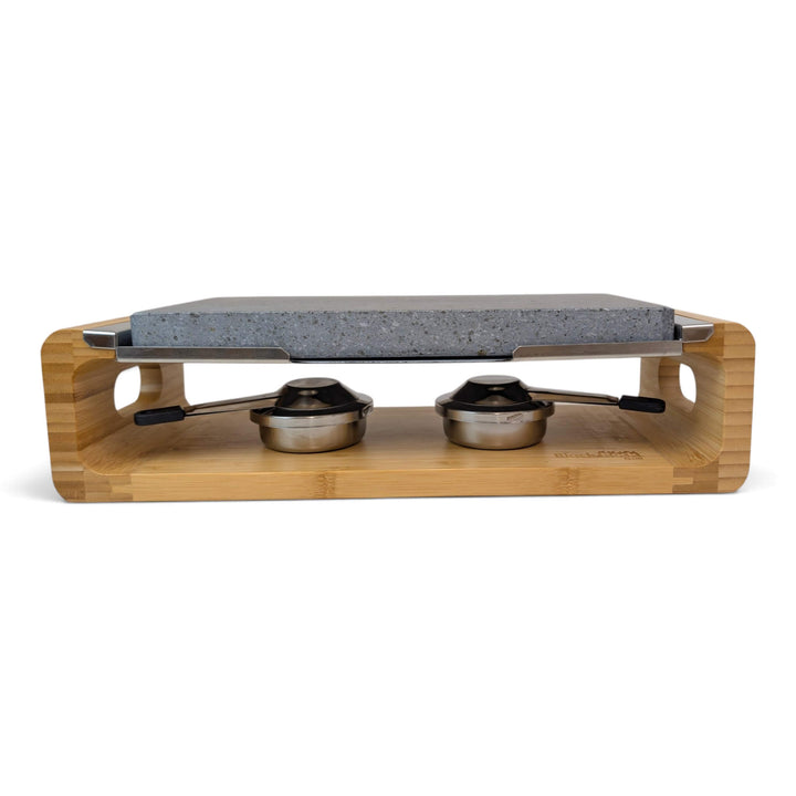 A bamboo-framed tabletop hot lava stone cooking set stove with two stainless steel gel burners to keep the stone hot for longer, photographed on a clean white background.
