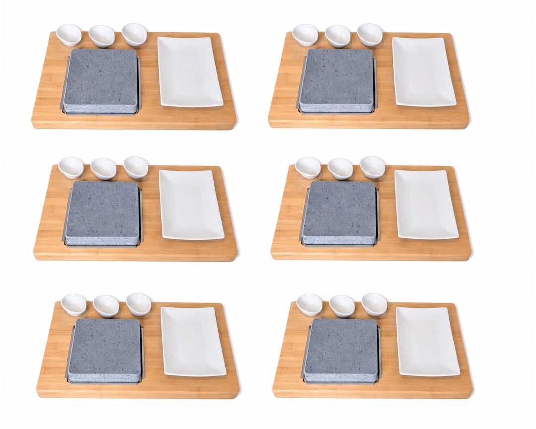Six identical lava rock cooking sets arranged in a 3x2 grid on a white background. Each set includes a rectangular bamboo board, a square lava cooking rock, a white rectangular ceramic plate, and three small white ceramic dipping pots.