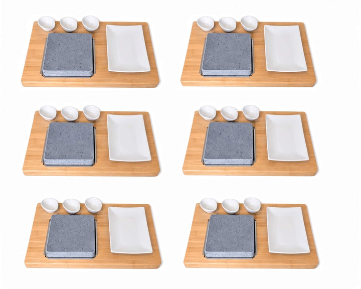 Six identical lava rock cooking sets arranged in a 3x2 grid on a white background. Each set includes a rectangular bamboo board, a square lava cooking rock, a white rectangular ceramic plate, and three small white ceramic dipping pots.