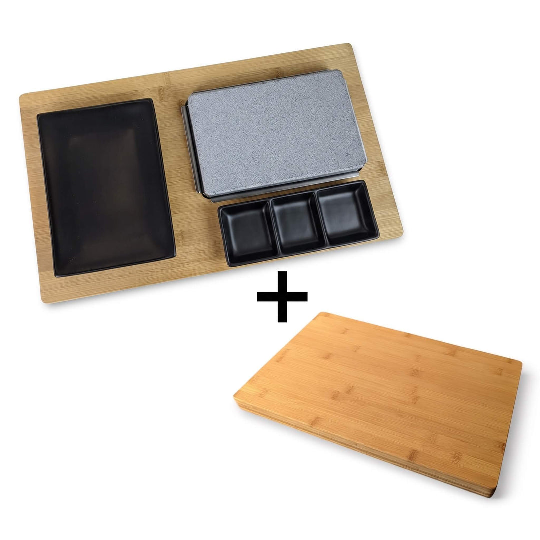 Featuring the Black Rock Grill Black Steak Stone Cooking Set, this bundle includes a sleek bamboo serving tray with a gray stone slab, three small black dishes, one large black dish, and a FREE £19.99 plain bamboo cutting board (indicated by a plus sign below). Perfect for an authentic hot stone cooking experience at home.
