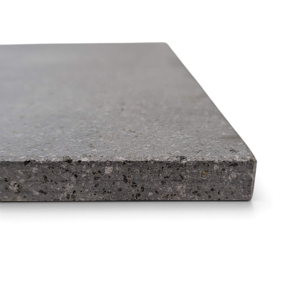 Side close up view of grey Lava pizza oven stone thickness image with view of beveled edges, shown on a plain white background.
