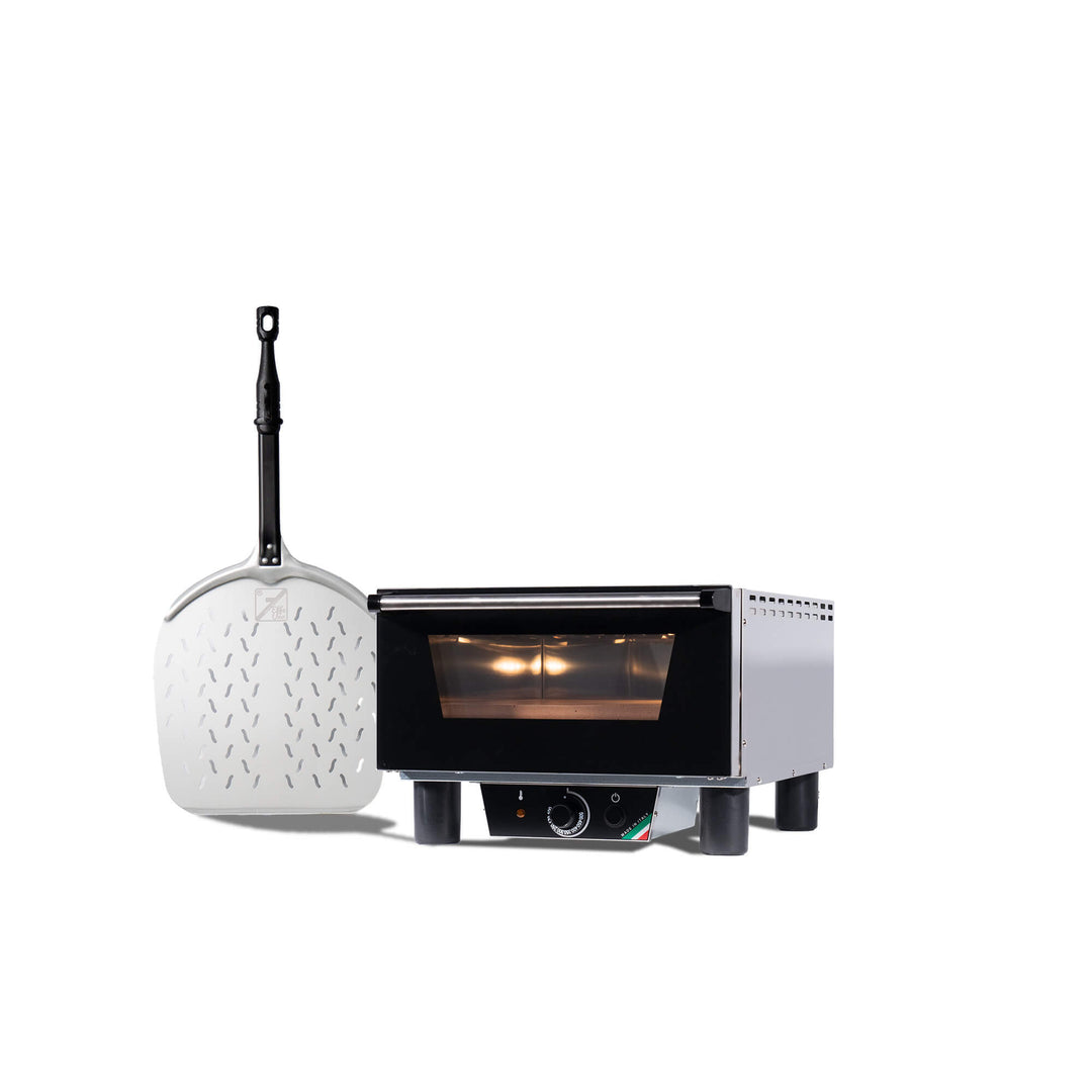 The Effeuno N3 Electric Pizza Oven, featuring a glass door and control knobs, stands beside a large metal pizza peel with a black handle, both set against a white background.
