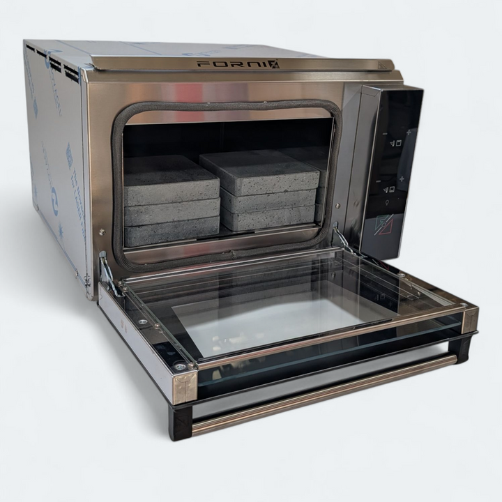 The Black Rock Grill ROXY12 is a stainless steel countertop oven featuring a glass door and right-side control panel. Inside, twelve stone slabs and plates make it ideal for tabletop cooking and interactive dining experiences.