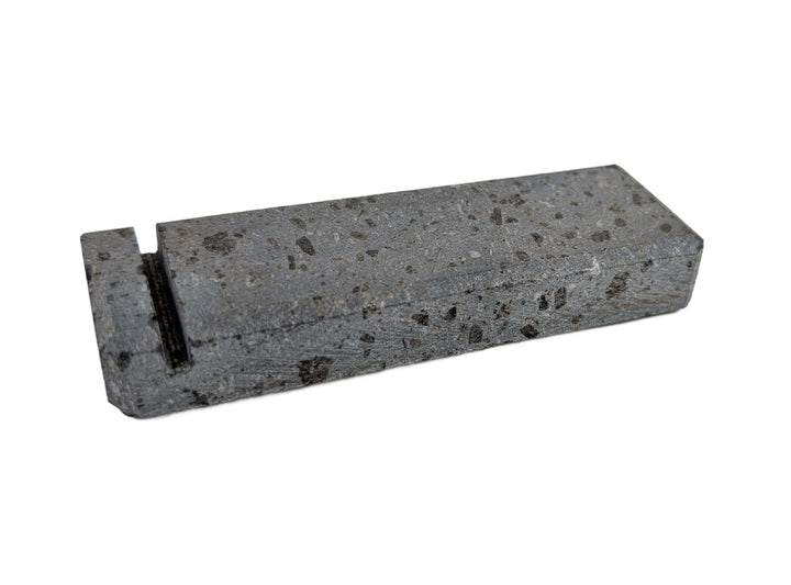 The Black Rock Grill Lava Rock Knife Rest – Limited Edition Table Accessory by Black Rock Grill is a rectangular, speckled gray volcanic stone block with a narrow black groove near one end, shown on a white background.