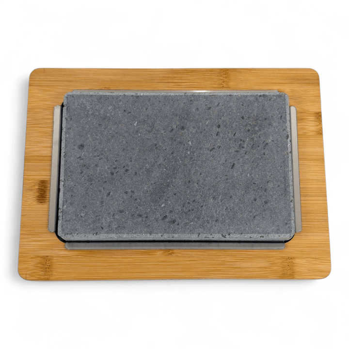 The Black Rock Grill Lava Sizzler Finishing Warming Platter features a rectangular gray stone on a wooden tray with metal support, displayed against a white background.
