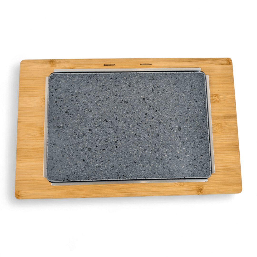 A rectangular gray lava stone slab rests on a light wooden board, creating the stylish Black Rock Grill Large Lava Sizzler Finishing Warming Platter, shown from above on a white background.
