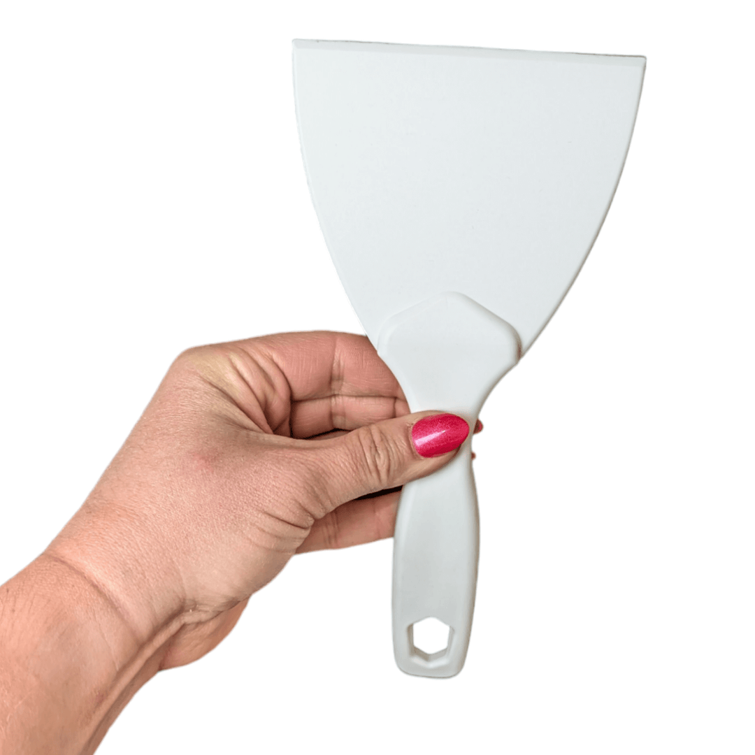 Single White Dough Paddle held between fingers of a ladies hand with red nail polish