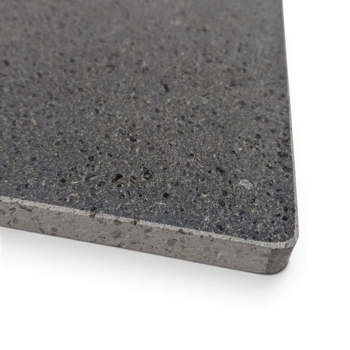 A close-up of a lava pizza stone corner with a beveled edge, shown on a white background.