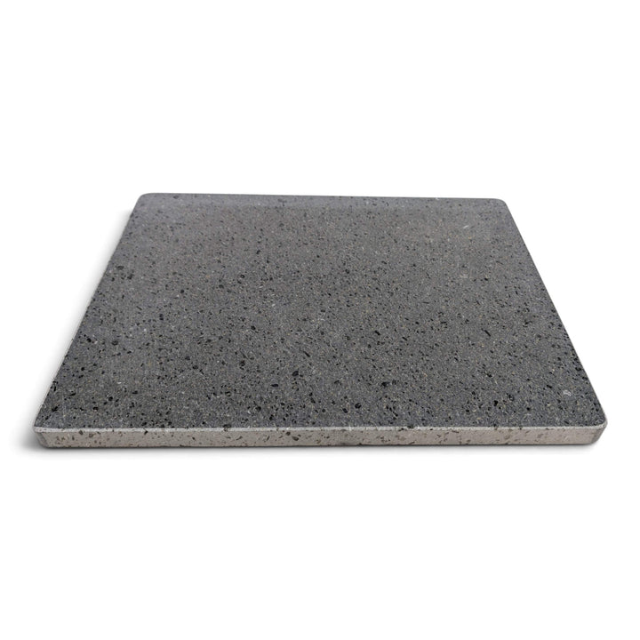 A rectangular lava pizza baking stone with a speckled look, shown from above at a on a white background.