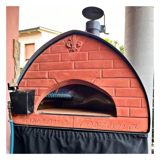 A Pizza Party Passione dual fuel outdoor pizza oven set up on a countertop in a outdoor setting.