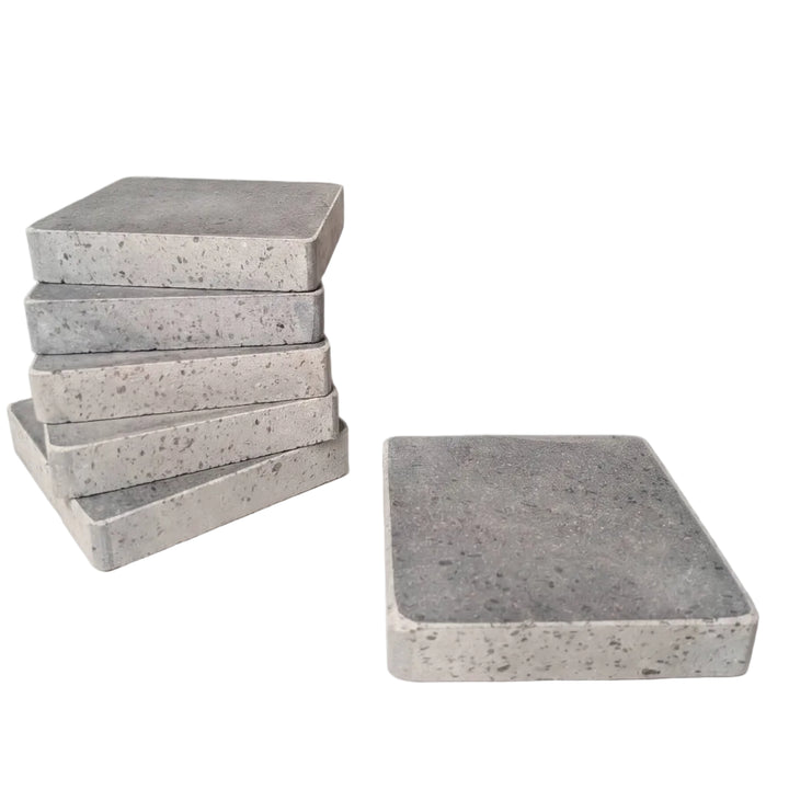A set of rectangular lava cooking stones, with five stacked on the left and one standing on the right, photographed on a clean white background.