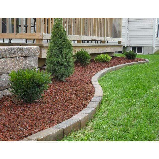Black Rock Grill Lava Rocks laid in a garden border with plants