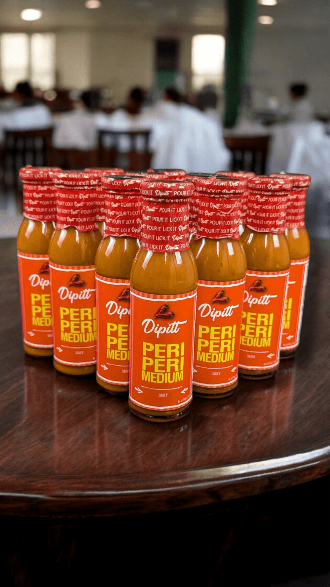 Dipitt Peri Peri Medium, case of 12 bottle on a restaurant table 