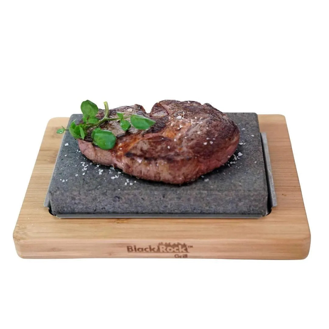 Steak Stone on a underplate and wooden bamboo board. Steak placed on the steak stone an sprinkled with salt