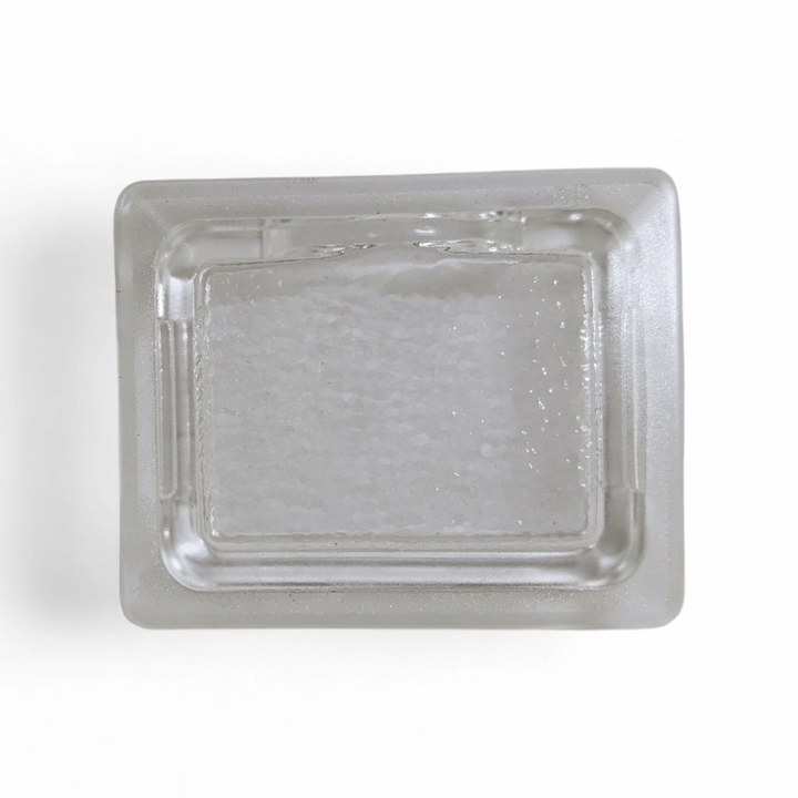 A clear, rectangular Effeuno Lamp Shade Glass- Flat Fitting by Effeuno is shown from above on a white background, filled with coarse white salt.
