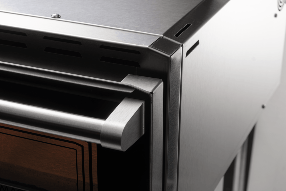 Close-up of the front right corner and sturdy door handle on the Macte Voyager Twin Advanced, highlighting the premium stainless steel build.