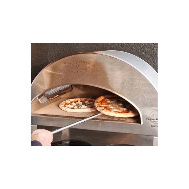 Person using a pizza peel to turn one of two pizzas cooking inside a Pizza Party Emozione outdoor gas pizza oven.